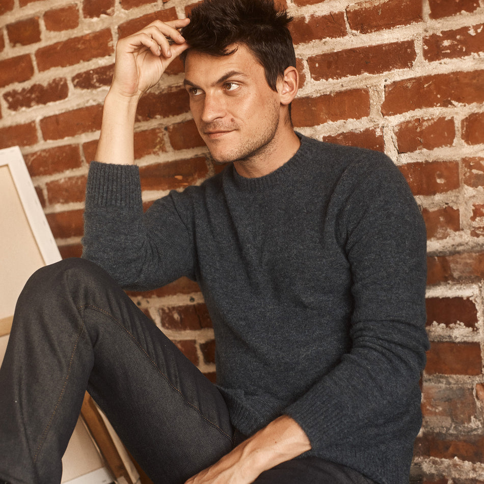 FRONT IMAGE OF MODEL SITTING WEARING ORRIN SWEATER